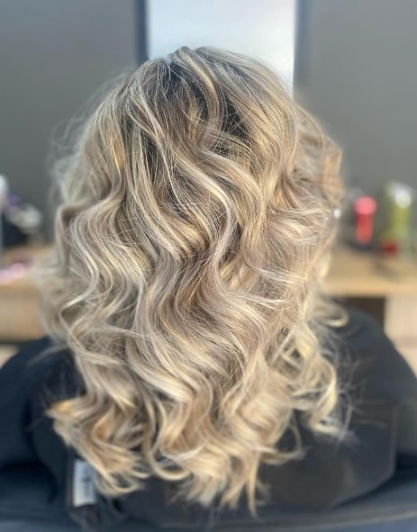 Blonde balayage styled in soft glamorous waves